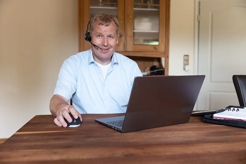 Mann am Esstisch mit Laptop im Home-Office