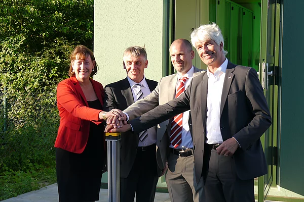 3 Herren und 1 Frau bei einem feierlichen Festakt, symbolisches drücken eines Startknopf