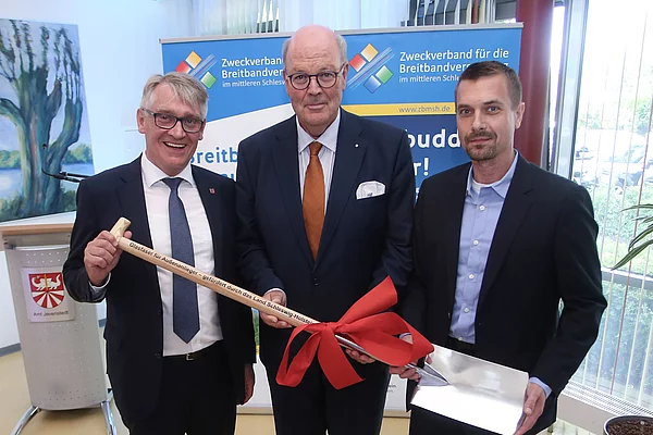 3 Herren mit einem geschmückten Spaten während eines Pressetermins im Amt anlässlich des 1. Spatenstichs